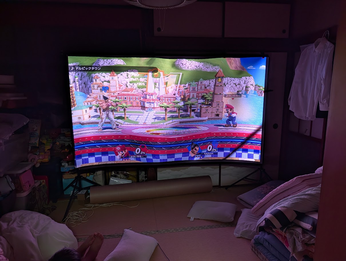 子供たちと100インチスクリーンで対戦ゲームを遊ぶ様子