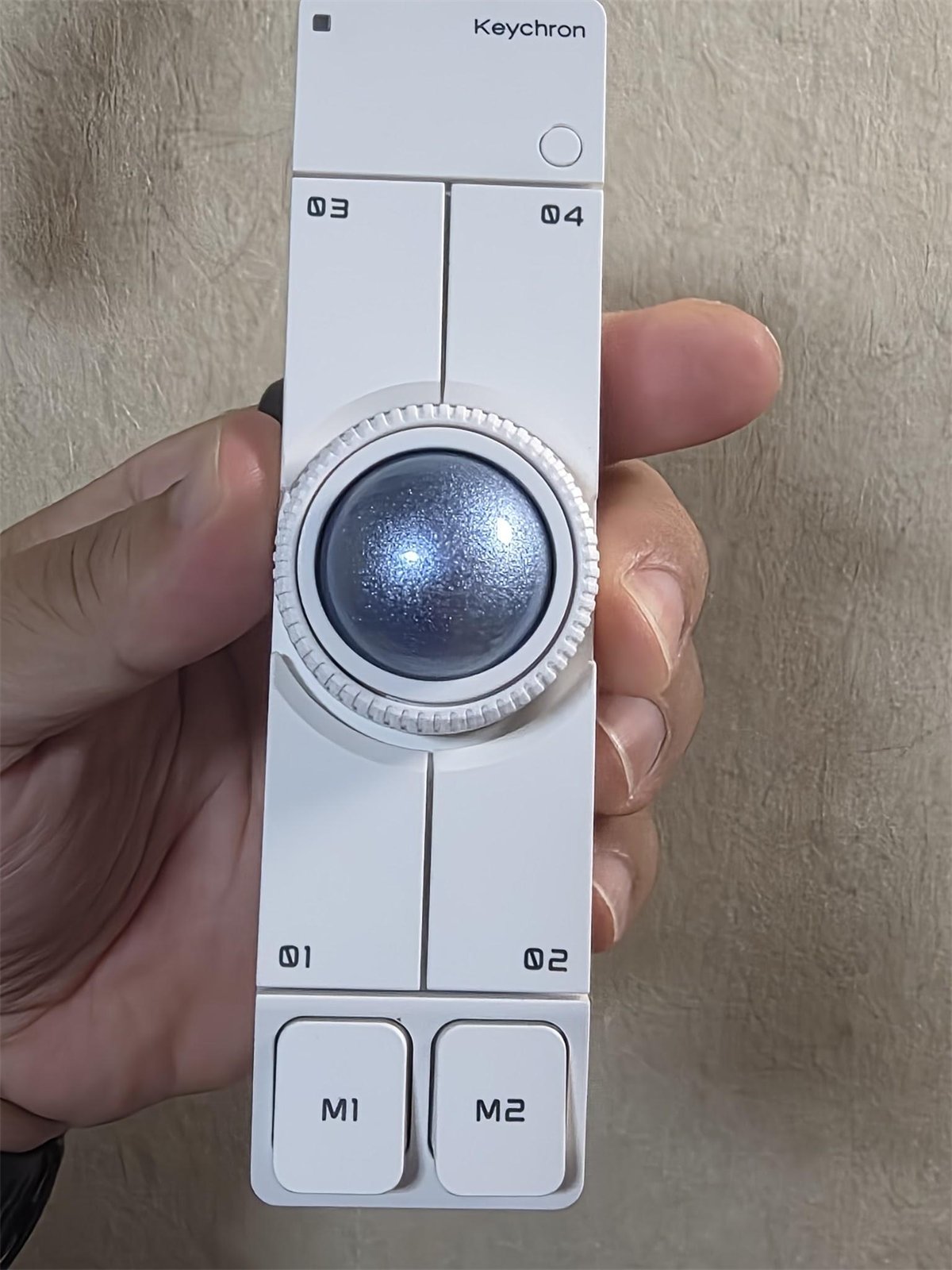 Keychron Nape Proホワイトを手に持ったところ。25mmトラックボールと6つのボタン