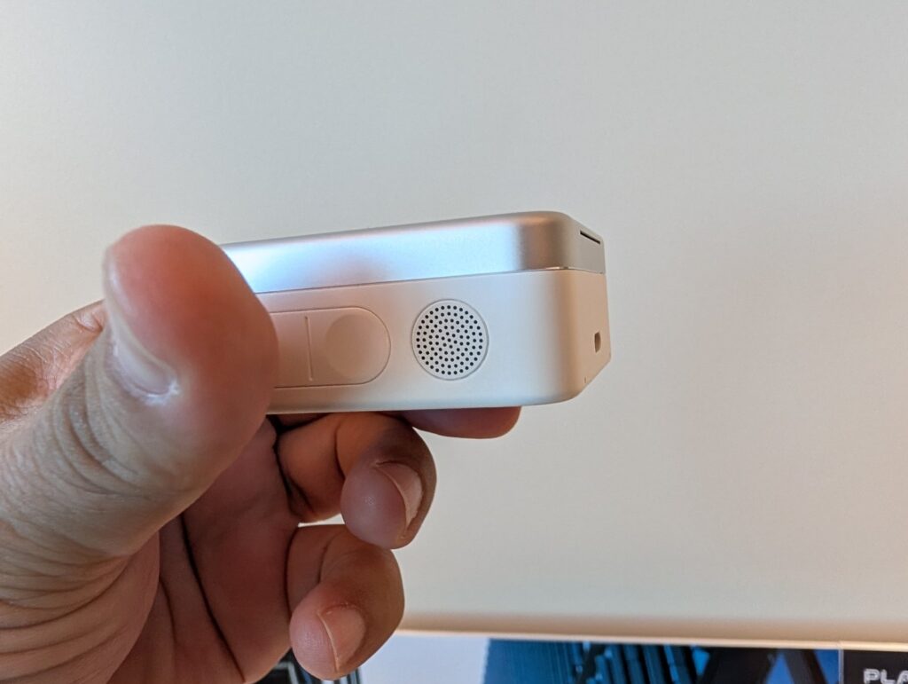 Plaud Oneの充電ケースを斜めから見た様子。側面のボタンとスピーカー
